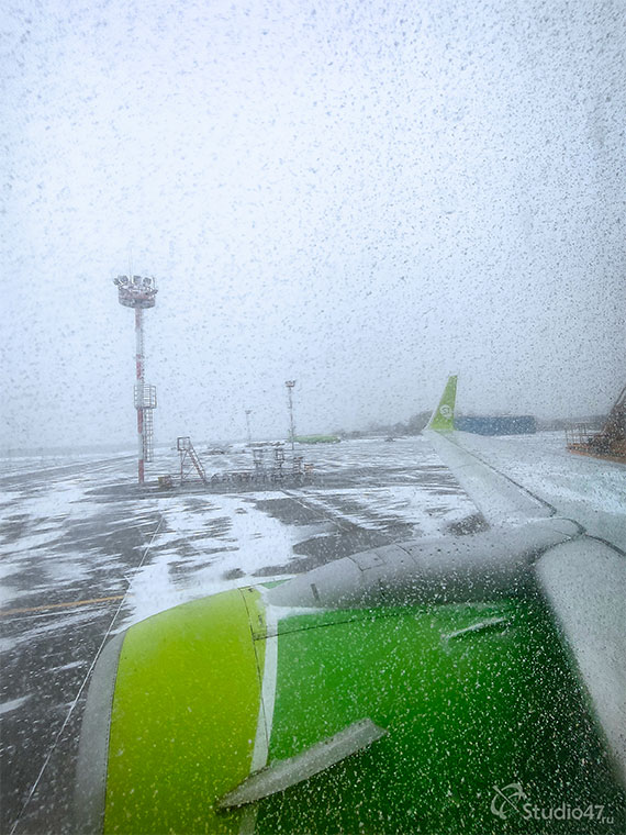 Снег на крыльях самолета